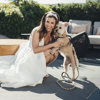 Bride smiling with her dog at the Shay hotel on her wedding day.