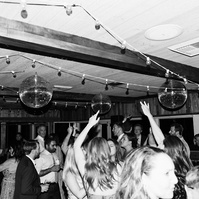 Candid black and white flash wedding photography of family and friends celebrating on the dance floor at Duke's Malibu.