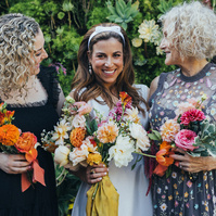Bride family photo on her wedding day with mother and sister and flowers.