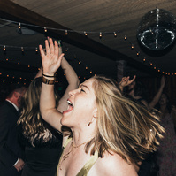 Flash photography of a guest at a wedding enjoying celebrating and dancing the night away.