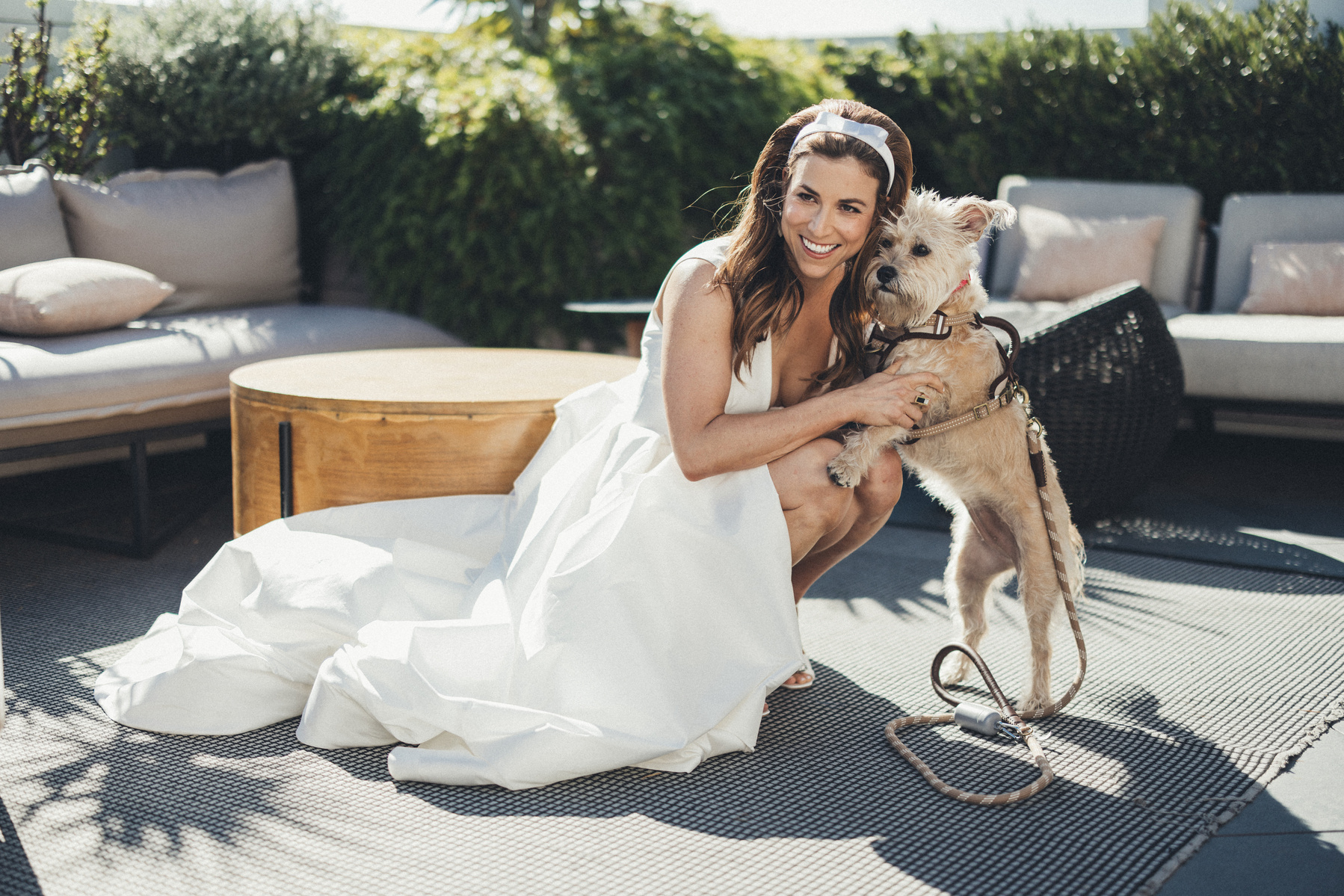 Bride smiling with her dog at the Shay hotel on her wedding day.