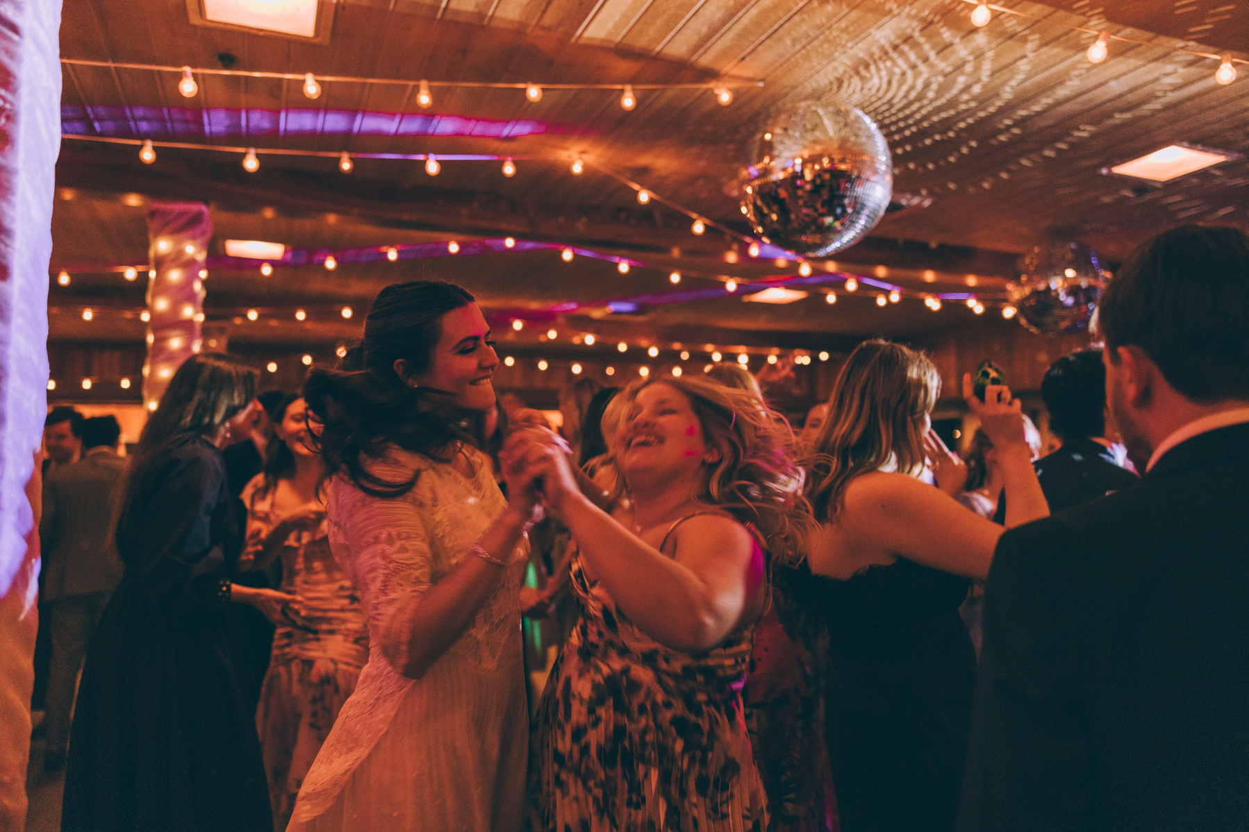 Wedding photography of a bride and her friend dancing on her wedding day by wedding photographer Abigail Gorden.