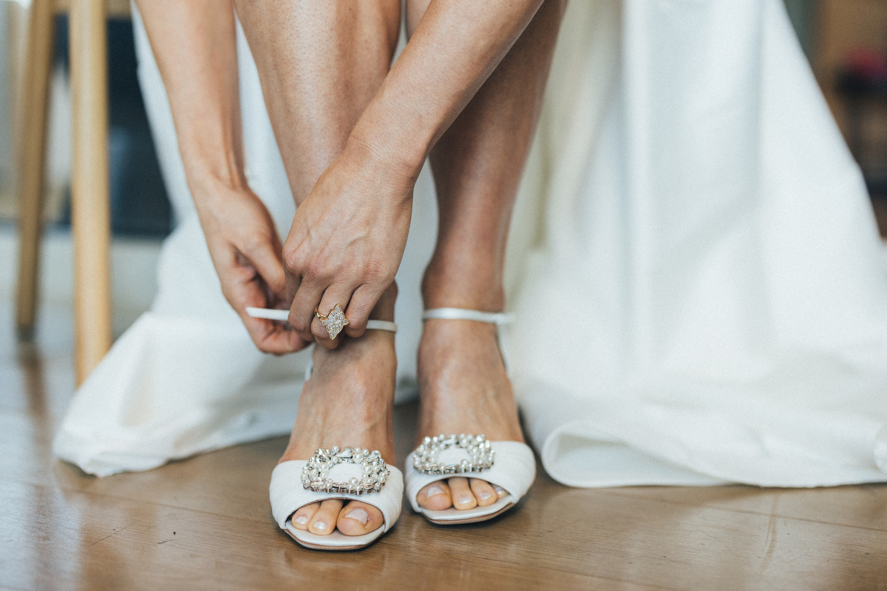 Photography detail shot of bride putting on her wedding shoes.