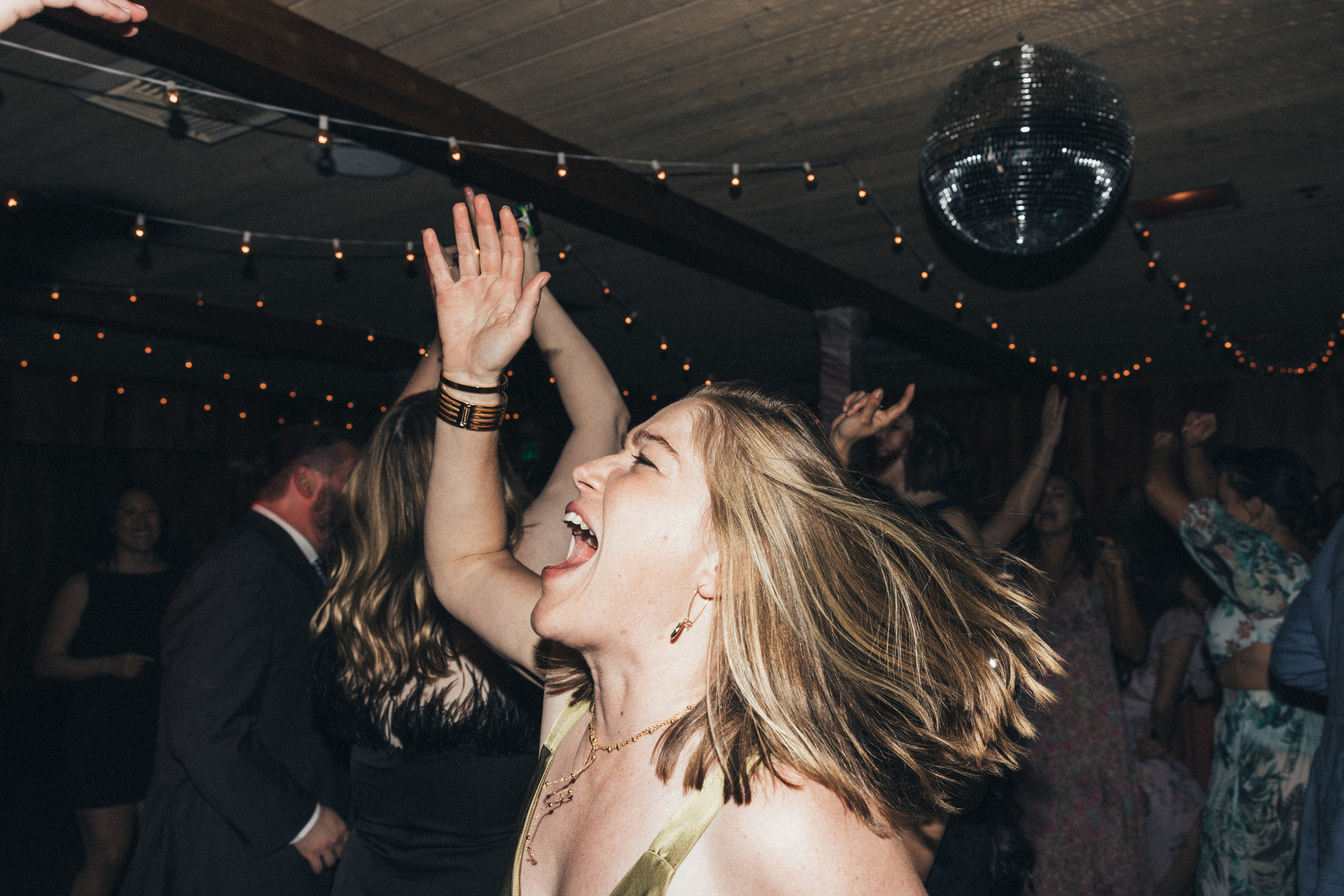 Flash photography of a guest at a wedding enjoying celebrating and dancing the night away.