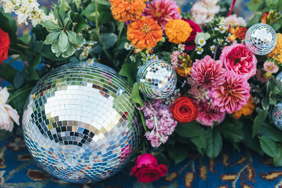 Stunning wedding detail shot featuring vibrant flowers and a sparkling disco ball, captured by Abigail Gorden Photography. Perfectly blending elegance and fun.