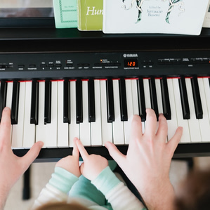 Dad's hands playing piano with daughter