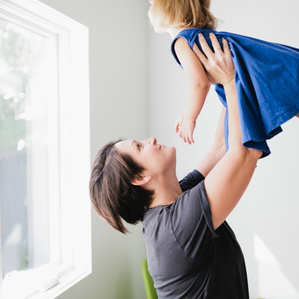 Mother holds daughter up in the air