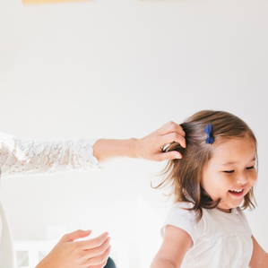 Mother swoops hair out of daughters face