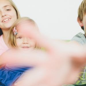 Kids reach toward camera while smiling