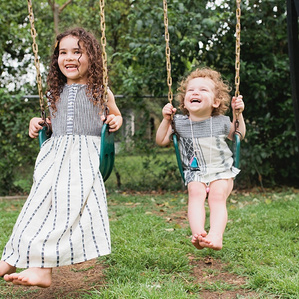 Sisters laugh together on swing set