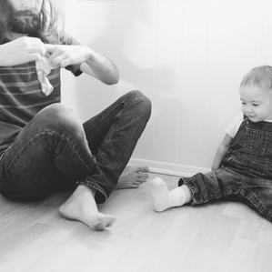 Father helps daughter put on socks and shoes