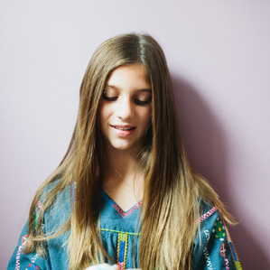 Girl stands next to purple wall