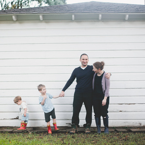 Mom and Dad stand next to boys in backyard