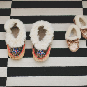Mother and daughters matching house slippers on rug