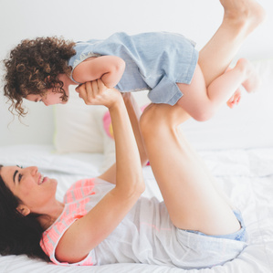 Mother holding daughter on bed