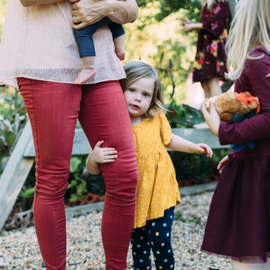 Girl hugs Mom's leg while siblings are nearby