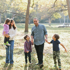 Family walks together in park smiling