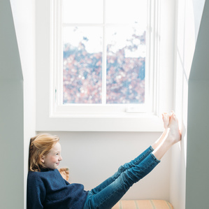 Girl sits in attic window