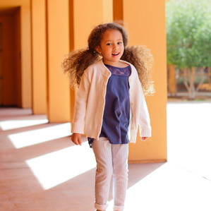 Little girl with big hair jumps in the air