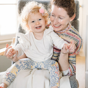 Mother and baby smile together in rocking chair
