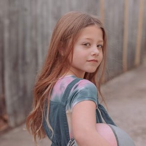 Young girl in overalls with basketball
