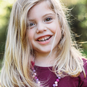 Young girl smiling at camera outside