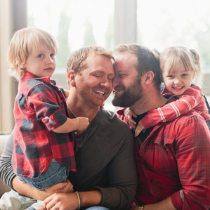 Two Dads are embraced by kids