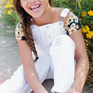 Girl ties shoes while laughing at camera