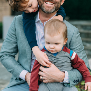 Father sits with sons on front porch