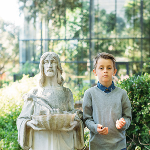 Boy stands next to statue at museum