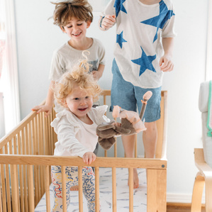 Kids play together in baby crib