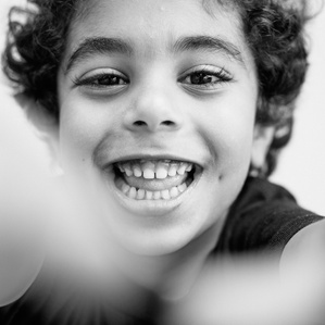 Boy reaches out toward camera while smiling