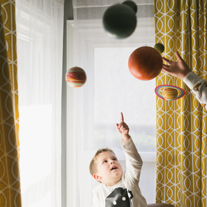 Little boy points to solar system plants in bedroom