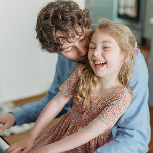 Dad and daughter playing piano and laughing together