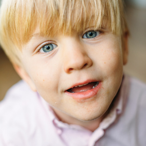 Young blue eyed boy looks into camera