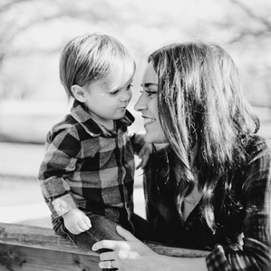 Mother holds baby boy on fence