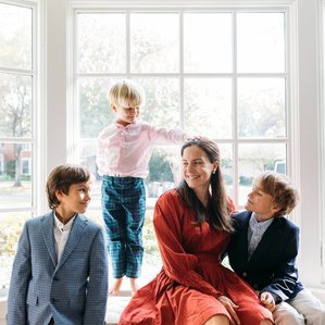 Mother sits in window bench with sons