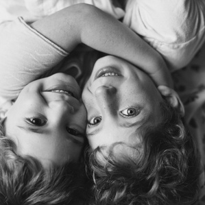 Sons embrace each other on bed