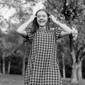 Teenage girl laughing and twirling outside
