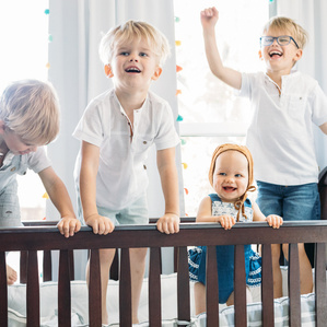 4 kids jump together inside baby crib