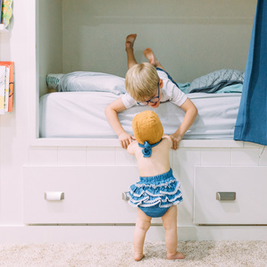 Brother and sister play together in play room
