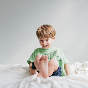 Little boy smiles on bed