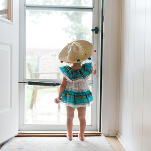 Girl stands at door in sombrero