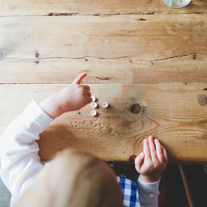 Little hands sort smarties candies on dining table