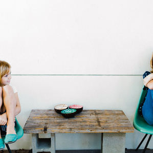 Sisters sit together on porch