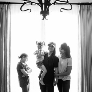 Two moms stand with daughters in dining room 