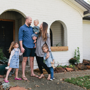 Family stands in front of home together