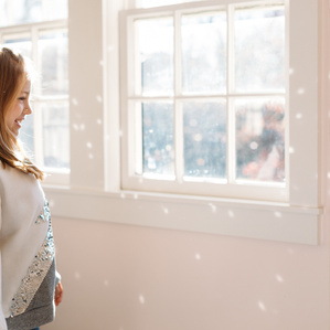 Girl admires glittery reflections from her sequin sweater