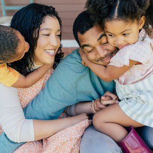 Mom and dad get embraced by kids on front porch