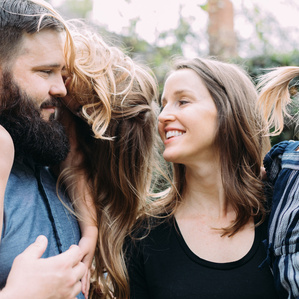 Mom and Dad gaze at each other while kids hand on shoulders